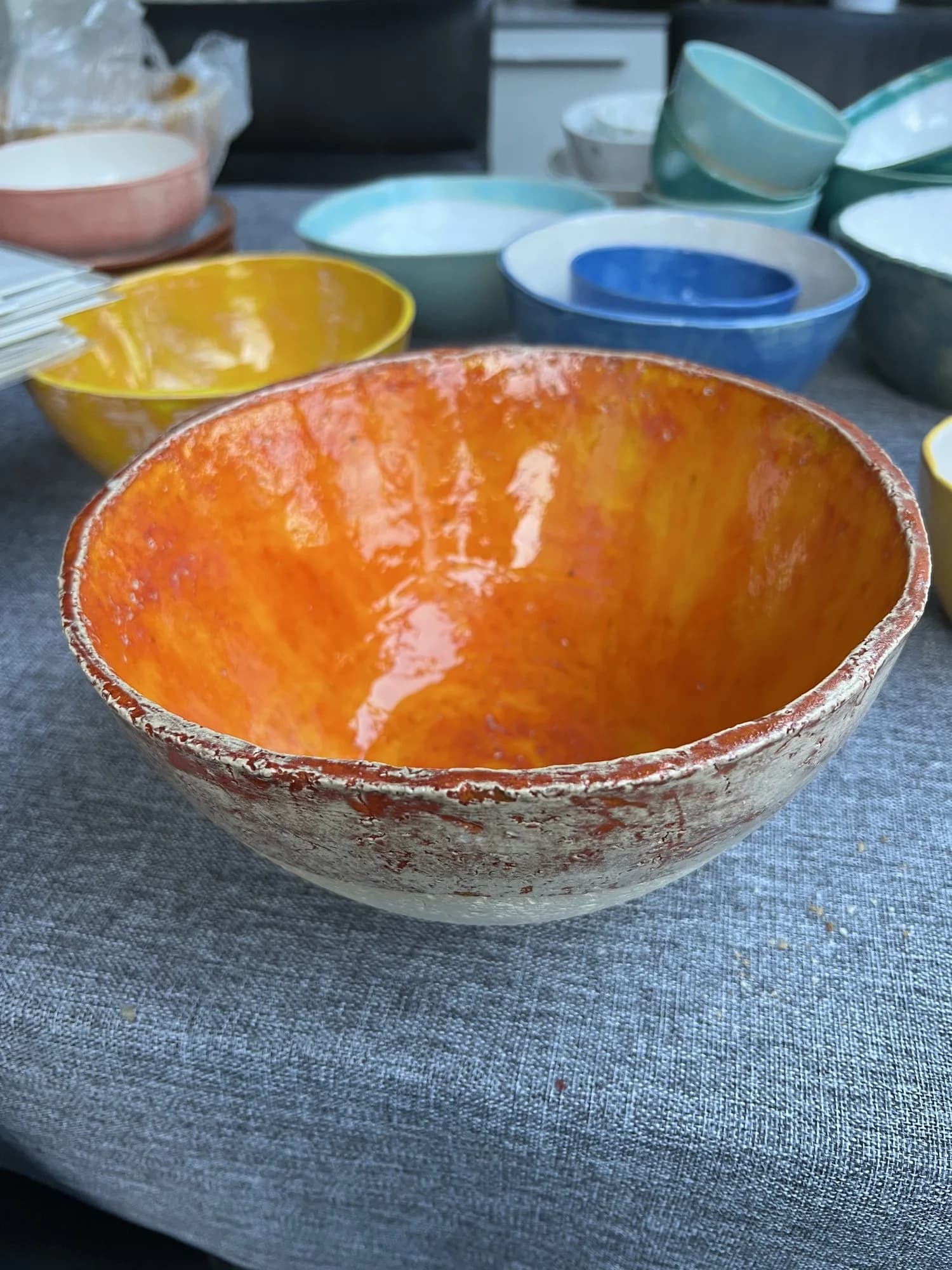 Nahaufnahme einer großen Keramikschale mit leuchtend oranger Glasur.